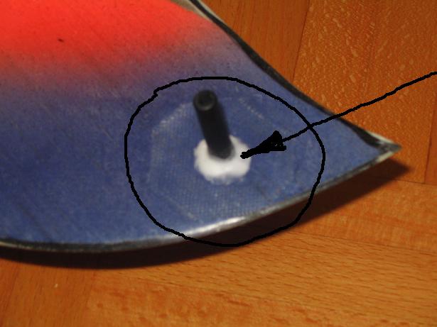 Štift za met in ojačitev. Z krogom je označena 80g steklenka, puščica pa kaže nanos mikrobalonov zmešanih z epoksi smolo. Na spodnji strani krila je narejeno po istem postopku.