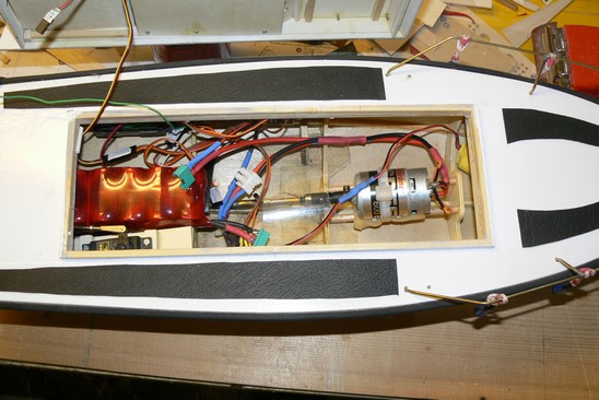 Tanšna je notranjost mojega čolna.<br />V njem vidimo motor SPED 600, paket baterij 7x2400 NMH, vidi se servo za smer, v prednjem delu se vidi malo baterije, ki jo uporabljam za plave luči , in pa sireno, vidi se tudi kabljeki gredo proti robu kjer jr sprejemn